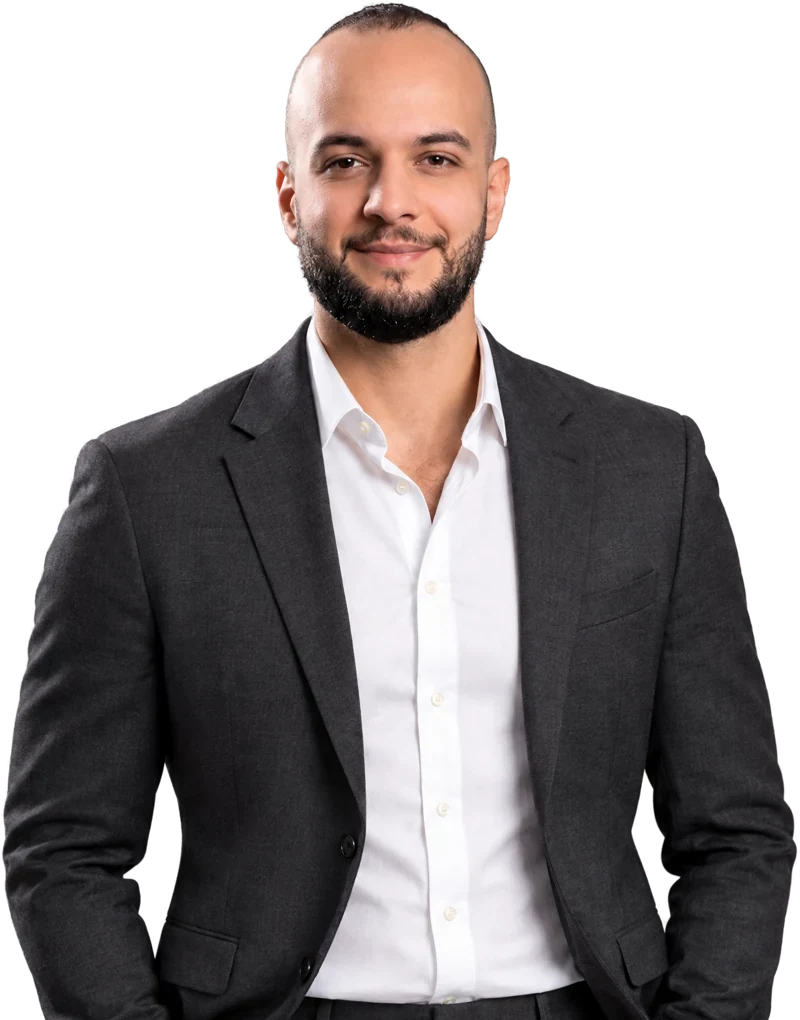 Majd Othman in a charcoal suit and white shirt, smiling